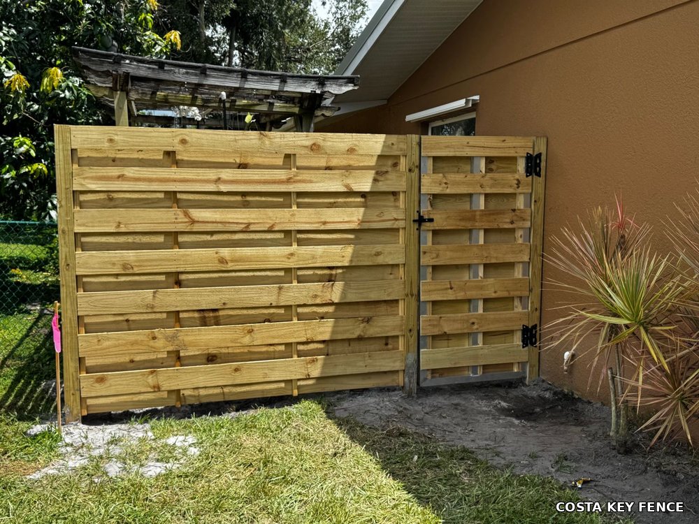 Horizontal wood fence and matching gate installed by Costa Key Fence beside a home near Sarasota, Florida