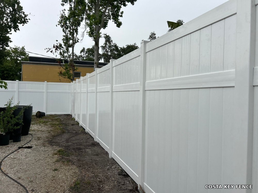 White vinyl privacy fence along a property line installed by Costa Key Fence near Sarasota, Florida